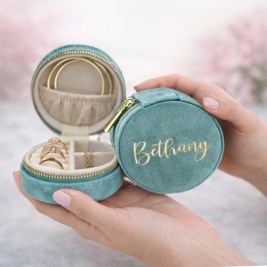 Teal jewelry box with 'Bethany' engraving, held by a hand with pink nail polish.